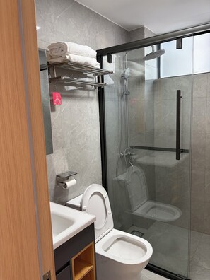 A modern bathroom with a glass-enclosed shower, a toilet, and a sink. - Serene 2-bedroom apartment perfect for your Nairobi getaway (Nairobi)