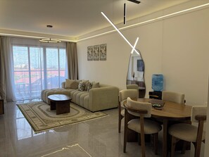 A modern living room with a sofa, coffee table, dining table, chairs, and a large mirror. - Serene 2-bedroom apartment perfect for your Nairobi getaway (Nairobi)