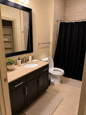 Ein Badezimmer mit Waschbecken, Toilette und Duschvorhang.