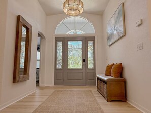 A hallway with a wooden bench, a rug, and a door with stained glass. - Rotonda West Escape with Pool, BBQ, Bikes and Beach Gear Near Boca Grande (Rotonda West)