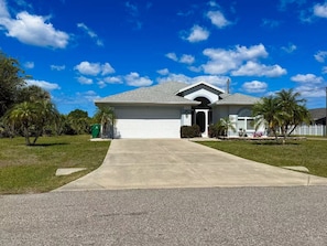 A single-story house with a garage, a driveway, and a lawn. - Rotonda West Escape with Pool, BBQ, Bikes and Beach Gear Near Boca Grande (Rotonda West)
