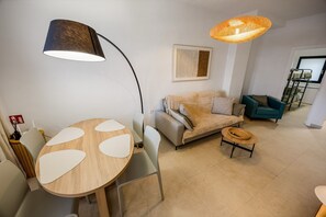 Ein modernes Wohnzimmer mit einem runden Tisch, zwei Sofas, einem Couchtisch und einer großen Stehlampe.