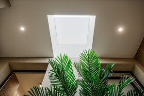 A modern interior with a recessed ceiling light, a geometric wall panel, and green plants. - 3-bedroom townhome in adorable San Pedro del Pinatar with AC (San Pedro del Pinatar)