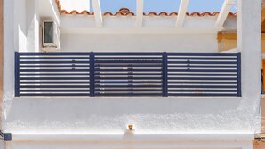 Un edificio de dos pisos con un balcón, una puerta y una ventana.