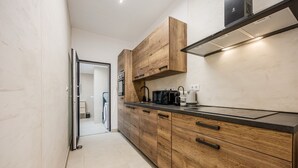 Una cocina moderna con armarios de madera, encimera negra y estufa empotrada.