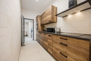 Eine moderne Küche mit Holzschränken, einer schwarzen Arbeitsplatte und einem eingebauten Herd.