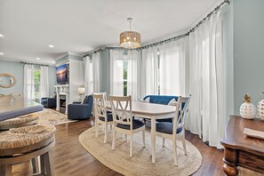 A dining area with a round table, chairs, and a chandelier. - Beautiful-Lakefront Farmhouse Retreat w/ Pool (Summerton)