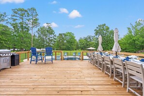 A wooden deck with outdoor seating, a grill, and a pool. - Beautiful-Lakefront Farmhouse Retreat w/ Pool (Summerton)