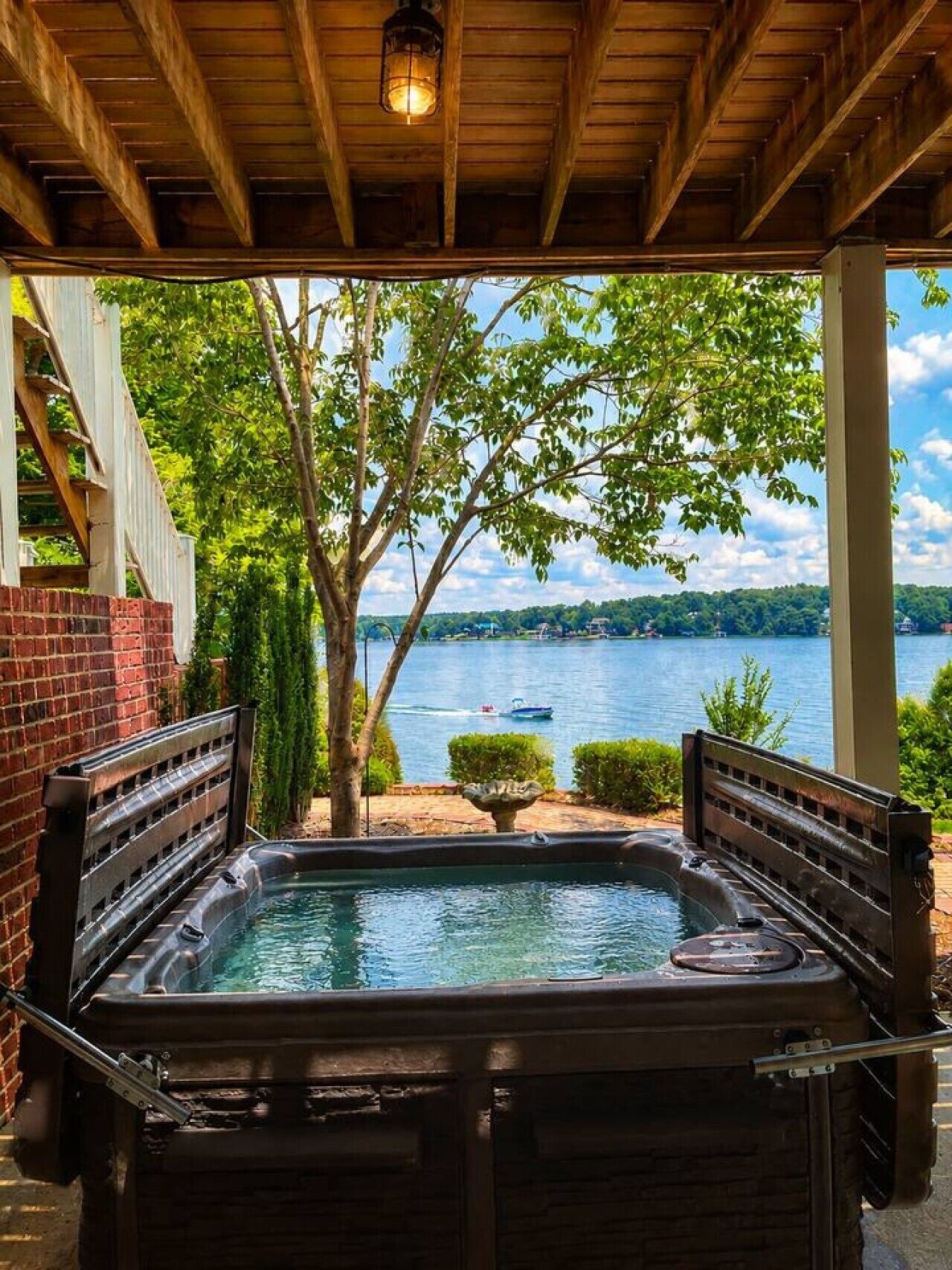 Un jacuzzi con vista a un lago y un bote.