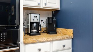 A kitchen with a coffee maker, a toaster, and a microwave. - Big Water Lodge | Hot Tub, Fire Pit, & Lake Views (Macon)