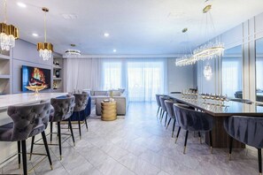 Une cuisine moderne avec un coin bar, des tabourets de bar et un grand miroir.