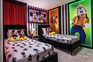 A hotel room with two beds, a red curtain, and Mickey and Minnie Mouse posters. - 10BR house with private pool in Windsor Island (Davenport)