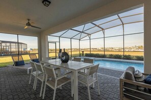 A covered outdoor area with a pool, seating, and a view of the landscape. - 10BR house with private pool in Windsor Island (Davenport)