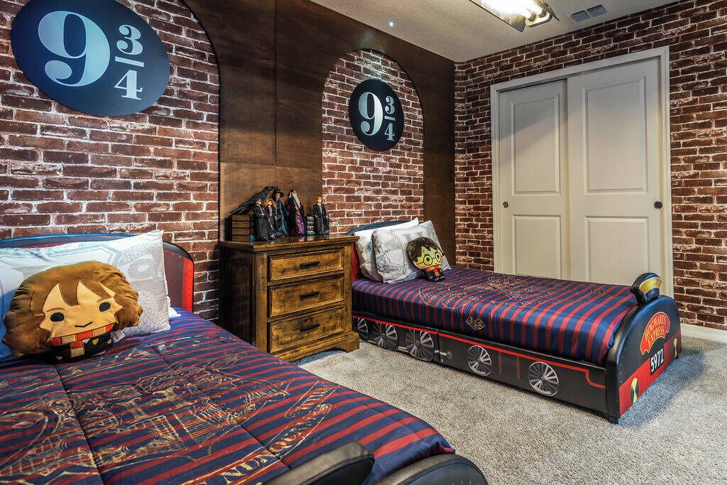 A bedroom with two beds, a dresser, and a door.