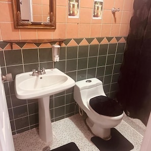 A bathroom with a white sink, a toilet, and a mirror above the sink.