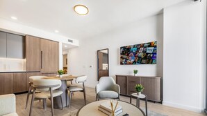 Een moderne woonkamer met een eethoek, een groot abstract schilderij en een minimalistisch interieur.