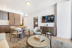 A modern living room with a dining area, a large abstract painting, and a minimalist design. - Miami Beach Luxury Stay Balcony Sea Views & Pool (Miami Beach)