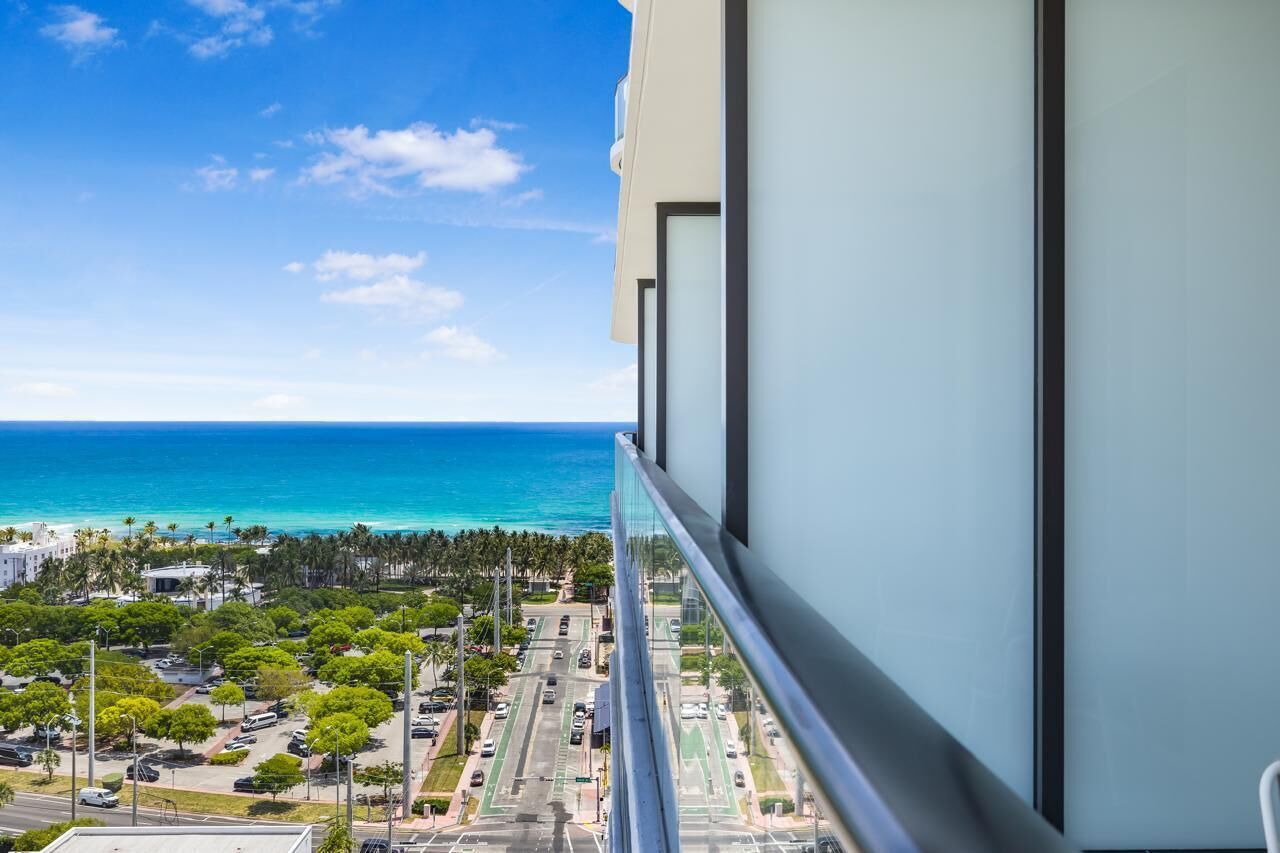 A balcony with a view of the ocean and a cityscape.