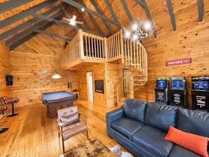 A wooden interior with a pool table, leather sofa, and arcade machines. - 3BR w/Hot Tub*Games*Privacy*15 mins to Dollywood (Sevierville)