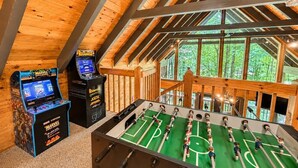 Ein Holzinterieur mit einem Kicker und zwei Spielautomaten.