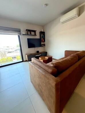 A modern living room with a sofa, TV, and shelves. - Lovely Guadalajara (Zapopan)