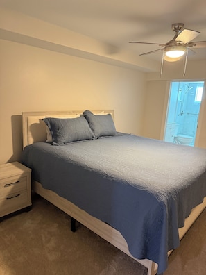 A bedroom with a bed, nightstand, and a ceiling fan. - Newly remodeled Beachfront 2BR-2Bath Condo / Pool & Gulf Views (Fort Myers Beach)