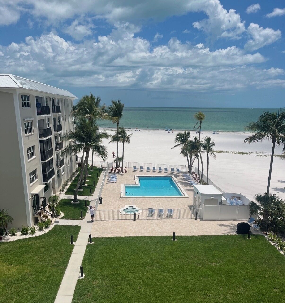 Un hôtel doté d’une piscine, d’une plage et de palmiers.