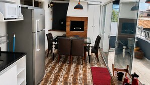 A modern kitchen with a built-in microwave, a stainless steel refrigerator, and a black oven. - Penthouse with ocean view, one block from the beach, with private garage. (Florianópolis)