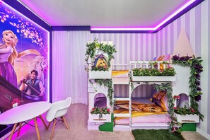 Ein Kinderzimmer mit Etagenbett, Schreibtisch und Wandmalerei.