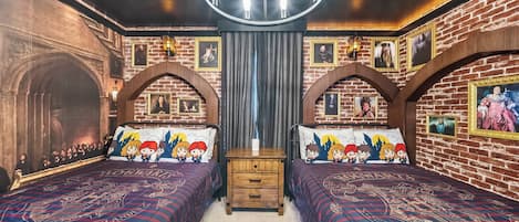 A room with two beds, a wooden dresser, and a chandelier.