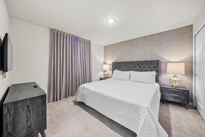 A hotel room with a bed, two bedside tables, a TV, and a curtain. - 10BR house with game room near Disney area (Davenport)