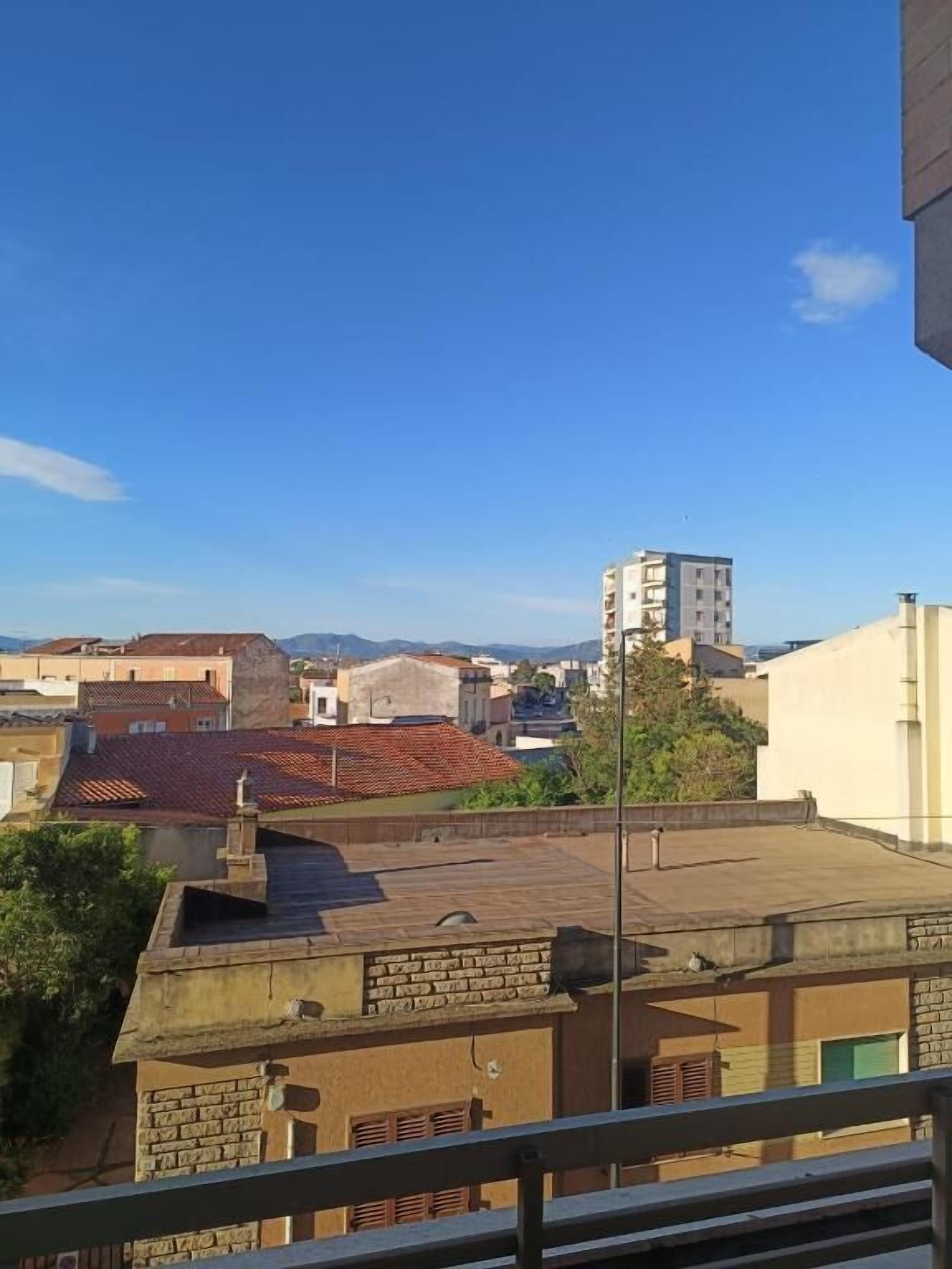 A residential area with buildings, a clear sky, and a balcony.