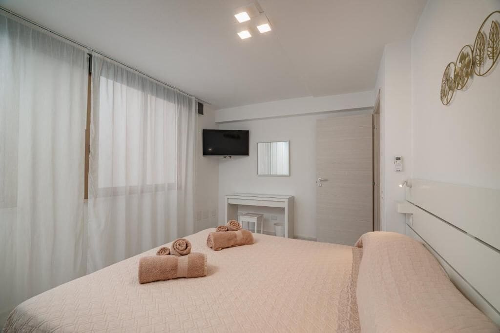 Une chambre d’hôtel équipée d’un lit, d’un téléviseur à écran plat, d’une cheminée et d’une porte.