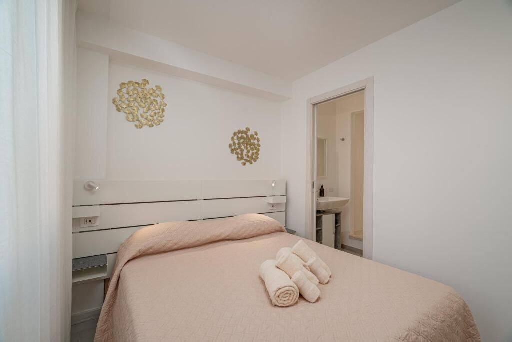 Une chambre à coucher comprenant un lit, une table de chevet, un miroir et un élément décoratif mural.