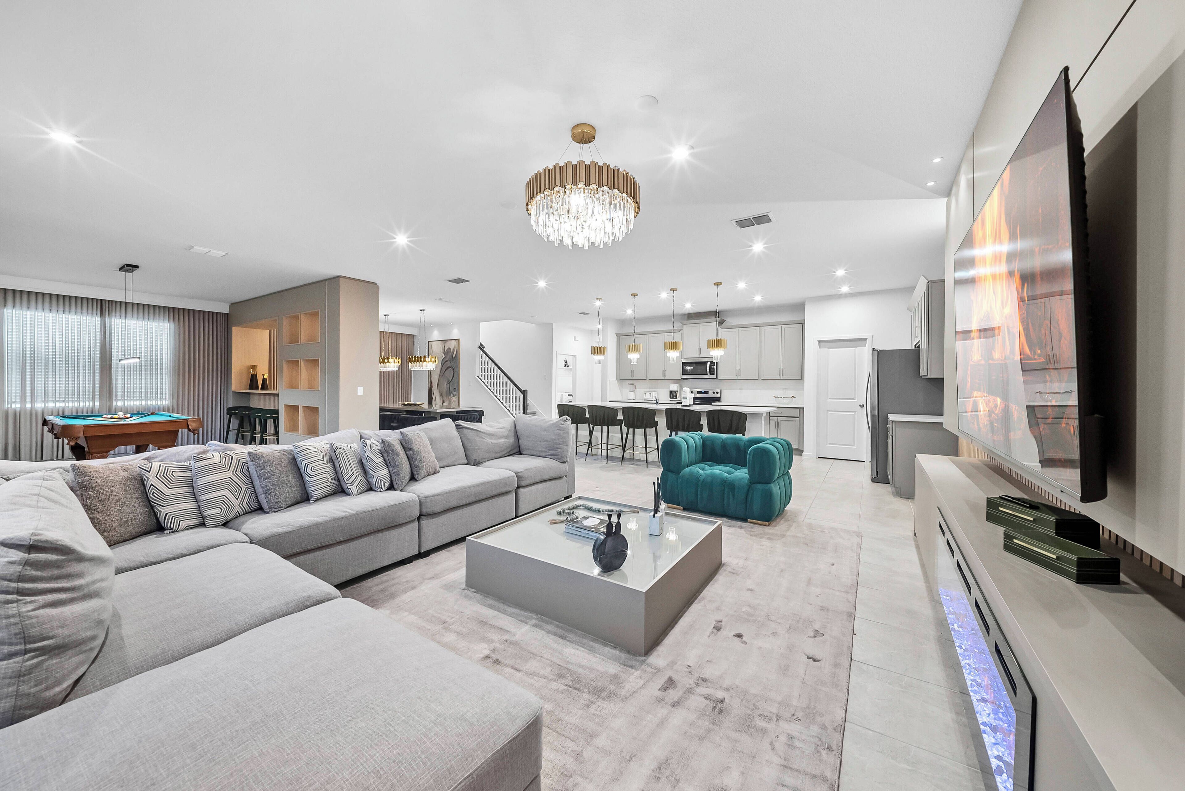 A modern living room with a grey sofa, a teal armchair, and a coffee table.