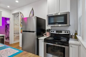 A modern kitchen with stainless steel appliances, a microwave, and an oven. - Music Row | 5 Legend-Themed Suites | Sleeps 26 (Nashville)