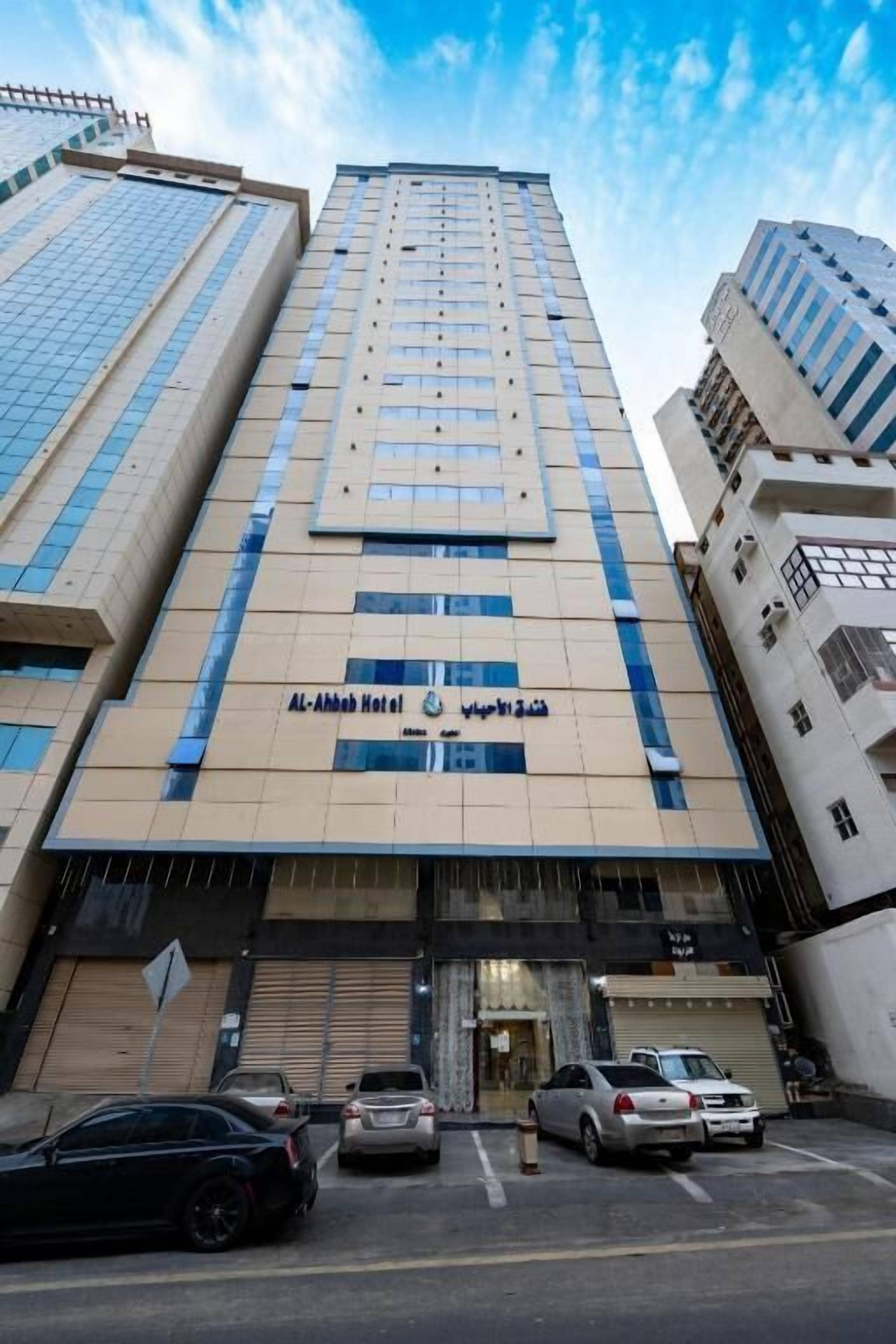 A tall hotel building with a modern facade, multiple floors, and a prominent entrance.
