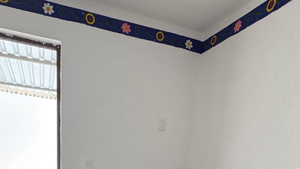 Et hjørnekontor med skrivebord, stol og skrivebordslampe.