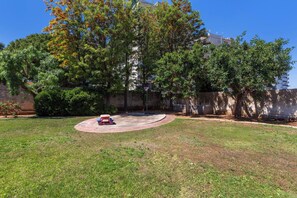A grassy yard with a red bench and a basketball hoop. - Ca` Mele by BarbarHouse (Lecce)