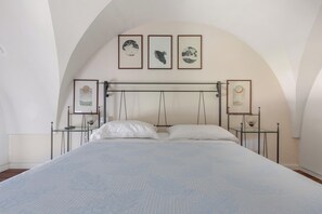 A bedroom with a bed, white pillows, a headboard, and three framed pictures on the wall. - Ca` Mele by BarbarHouse (Lecce)