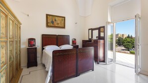 Ein Schlafzimmer mit einem Bett, einem Schminktisch und einem Bild an der Wand.