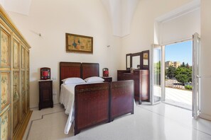 A bedroom with a bed, dresser, and a painting on the wall. - Ca` Mele by BarbarHouse (Lecce)