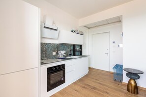 A modern kitchen with white cabinetry, a built-in oven, and a coffee machine. - Casa Sibiana by BarbarHouse (Gallipoli)