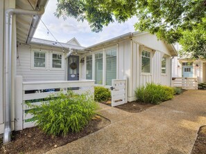 A white building with a porch, a gravel driveway, and green plants. - Peace of Mind - Pet Friendly Luxury Getaway in Carlton Landing (Eufaula)