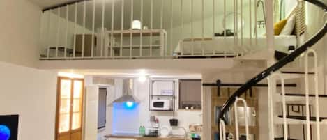 Eine zweistöckige Wohnung mit Essbereich, Küche und einer Wendeltreppe.