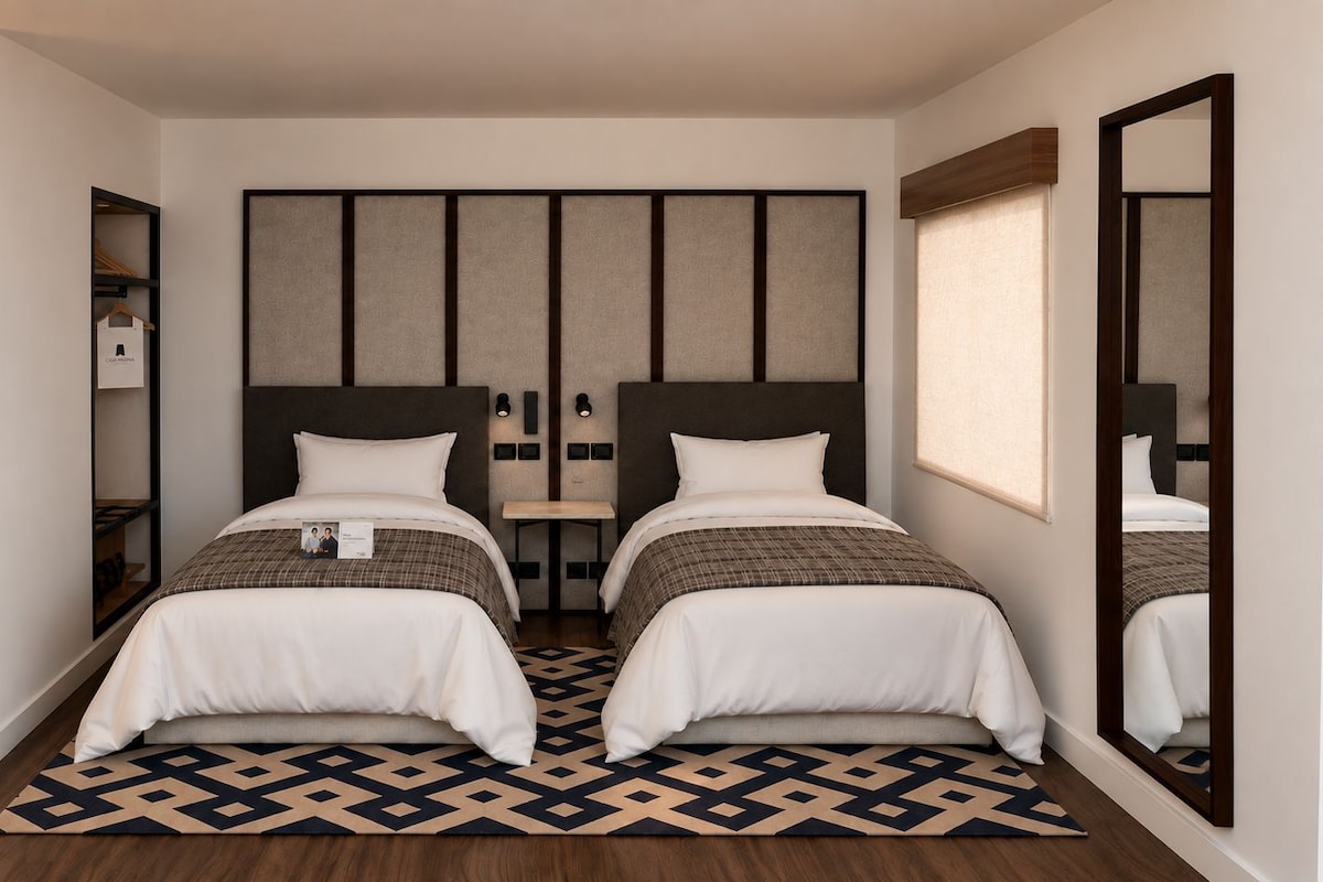 A hotel room with two beds, a large mirror, a wardrobe, and a patterned floor.