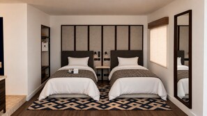 A hotel room with two beds, a large mirror, a wardrobe, and a patterned floor.