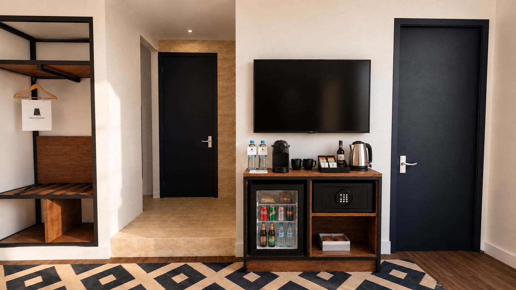 Una habitación de hotel con una cama, televisión, minibar y puerta.