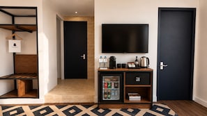 A hotel room with a bed, a TV, a minibar, and a door. - Casa Andina Premium Cusco El Mercado (Cusco)
