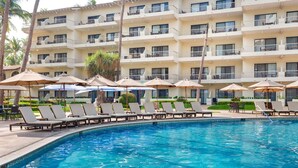 A hotel pool area with lounge chairs and umbrellas, surrounded by a multi-story building with balconies. - Awesome oceanfront resort with amazing Arch views in fabulous Cabo San Lucas (Cabo San Lucas)